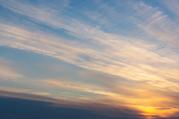 the sun sets in the clouds in the form of tracks.