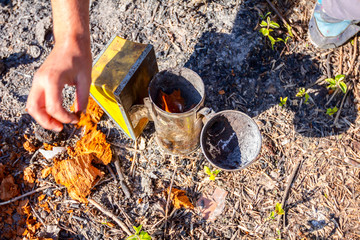 Apiarist, beekeeper prepare the smoker to use on a beehive