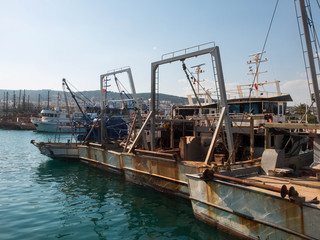 Fototapeta na wymiar Old rusty fishermen boats with winch hoisting mechanisms in the harbor