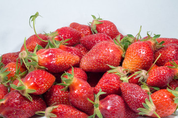 Many red strawberries. Group of home-made ripe strawberries. Vegetarian food from organic strawberry fruit. Close-up of red berries.