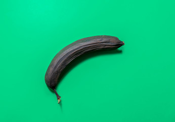 One overripe banana isolated on green background