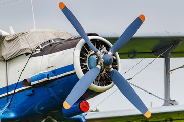 White and blue soviet aircraft biplane Antonov AN-2 at the parking on airfield closeup against...
