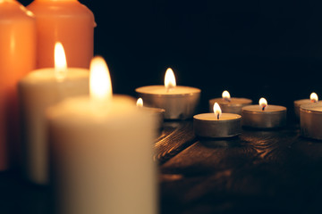 candles burning in darkness over black background. commemoration concept.