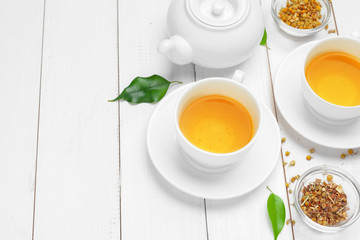 teapot and cups of tea on a white wooden background