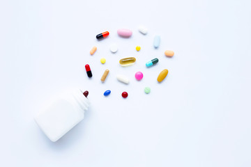 Colorful tablets with capsules and pills on white.