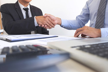 Real estate agent and customers shaking hands together celebrating finished contract after about home insurance and investment loan, handshake and successful deal