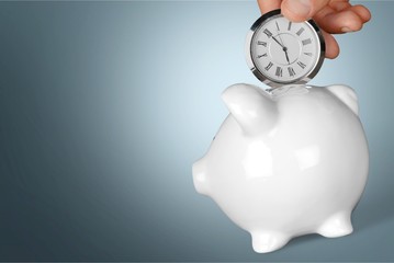 Businessman pointing at hand watch on grey wall background, close-up