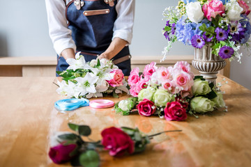 Arranging artificial flowers vest decoration at home, Young woman florist work making organizing diy artificial flower, craft and hand made concept