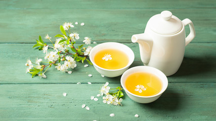 A cup of fragrant floral tea with petals on a wooden background. Selective focus. Copy space.