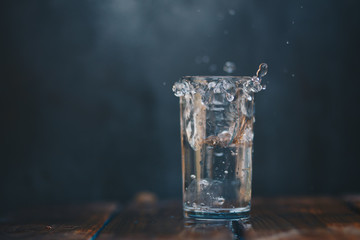 Splashing water from crystal glass On the wood floor