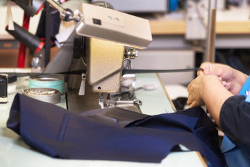 Woman tailor working on sewing machine. Hands. close up. Tailoring. Details .