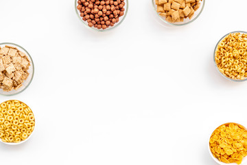 Various cereals in bowls on white background top view copyspace