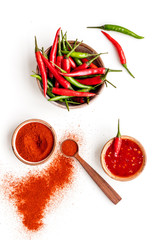 Cooking hot food with chilli pepper on white table background top view