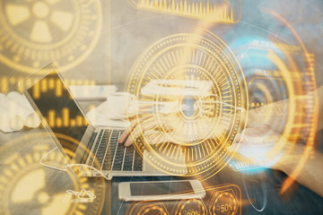 Technology theme hologram with man working on computer on background. High tech concept. Double exposure.