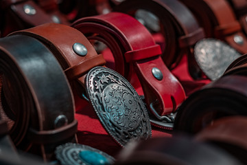 Details and close up shot of real American western clothing. Leather belts and silver buckles, rodeo lifestyle, southern patriotic symbols. Cowboy concept. 