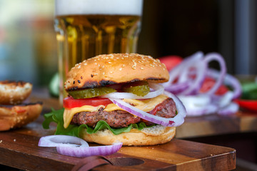 Tasty big burger and beer glass on wood table