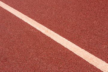 Fototapeta premium A white dividing diagonal on a red asphalt runway