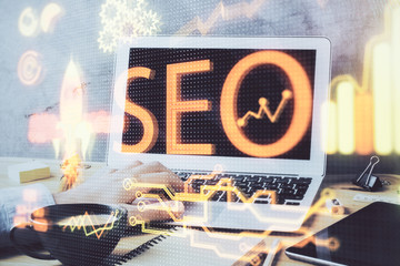 Multi exposure of seo icon with man working on computer on background. Concept of search engine optimization.