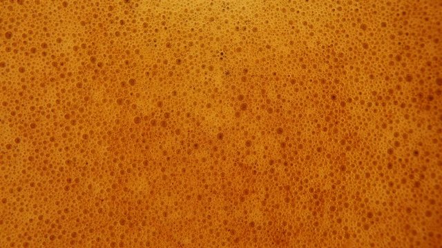 slider 4K macro video of close-up coffee bubbles background, espresso foam, Macro tilt up of espresso coffee poured in a cup and swirling with its cream and aroma. Italian coffee and drink.