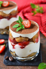 Italian dessert tiramisu with strawberries on an old grunge background