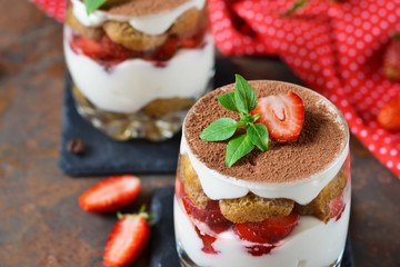 Italian dessert tiramisu with strawberries on an old grunge background