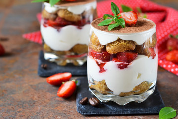 Italian dessert tiramisu with strawberries on an old grunge background