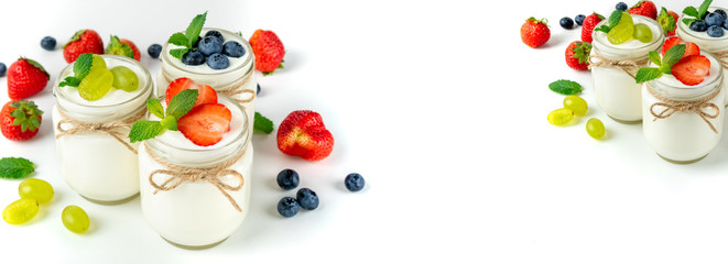 Fresh yogurt with berries in glass jars. Dairy products. Healthy food, dieting and breakfast concept. Long format for banner with copy space