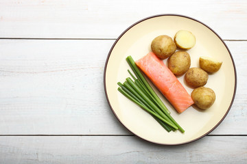 Boiled young potatoes with red fish and green onions