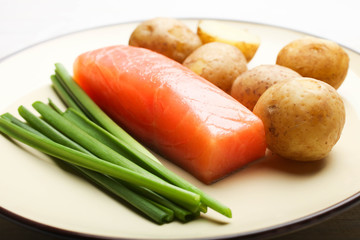 Boiled young potatoes with red fish and green onions
