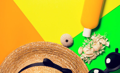Beach accessories on a bright neon colorful background. A fragment of a straw hat and sea urchin...