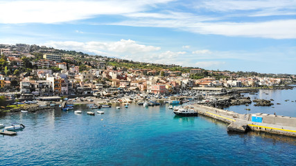 Fototapeta na wymiar Acitrezza Sicily aerial scenic panorama of the town, the port, blue sea and beautiful sky