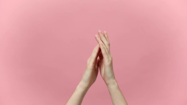 Woman hands clapping applause and showing two thumbs up gesture isolated over pastel pink background in studio. Copy space for advertisement. With place for text or image. Advertising area, mock up.