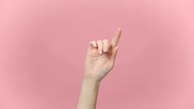 Woman hand touch something like push click on button, finger pointing at floating virtual screen isolated over pastel pink background in studio. Place for text or image, promotional content. Mock up.