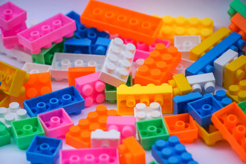 Multicoloured plastic construction blocks or bricks toy on white background