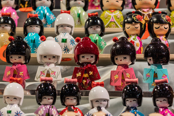 Close up macro shot of traditional asiatic miniature dolls. Oriental souvenirs, mass produced for...
