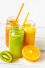 Fresh detox juices in glass bottles on white background