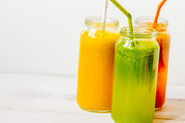 Fresh detox juices in glass bottles on white background