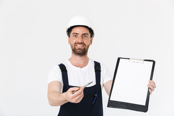 Confident bearded builder man wearing overalls standing