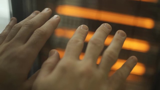 Rubbing hands next to a radiator in winter