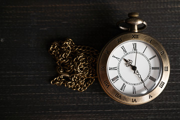 Antique pocket watch Placed on a black wooden background. copy space for text