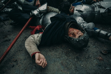 The murdered medieval knights lie on the battlefield.