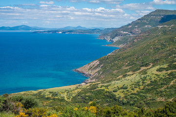 Fototapeta na wymiar Spectacular landscapes, awe-inspiring cliffs, charming villages and historical landmarks along the coastal road between Alghero and Bossa (SP 105), Sardinia, Italy. 