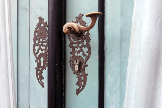 Ornate door handle on an old wooden door