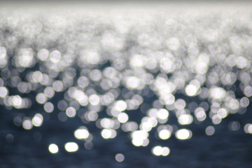Natural abstract sea water background with bokeh from sun glare on water.