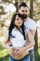 Fototapeta premium Happy young couple expecting baby in summer park