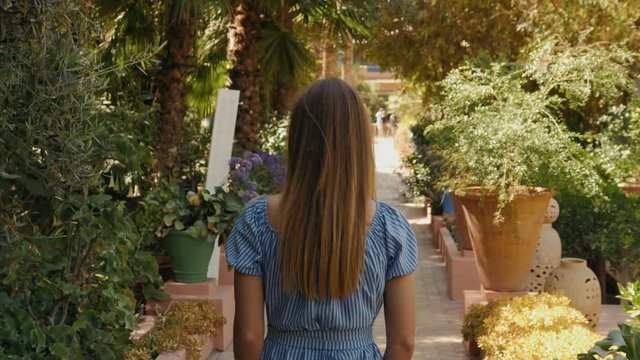 Woman tourist walking in exotic park near palms and flowers. Concept of tropical resort and summer vacations, girl in majorelle garden in marrakech marocco, arabian african