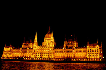 Fototapeta premium Budapest Hungary, 05.29.2019 Hungarian Parliament Building on the banks of the Danube River. night Budapest, glowing in gold. facade and roof of an old building