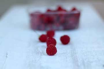Package full of freshly picked raspberries. Selective focus.