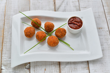 meatballs in breading on a white plate