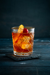 Whiskey sour cocktail with a slice of orange, cherry and ice, a classic alcoholic drink